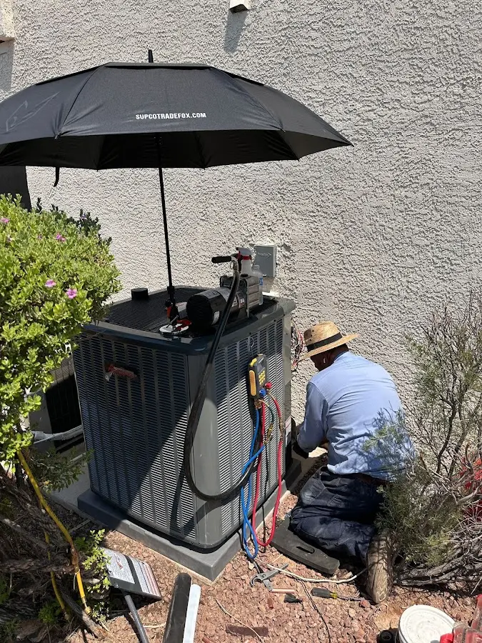 HVAC technician performing outdoor AC maintenance in Maili